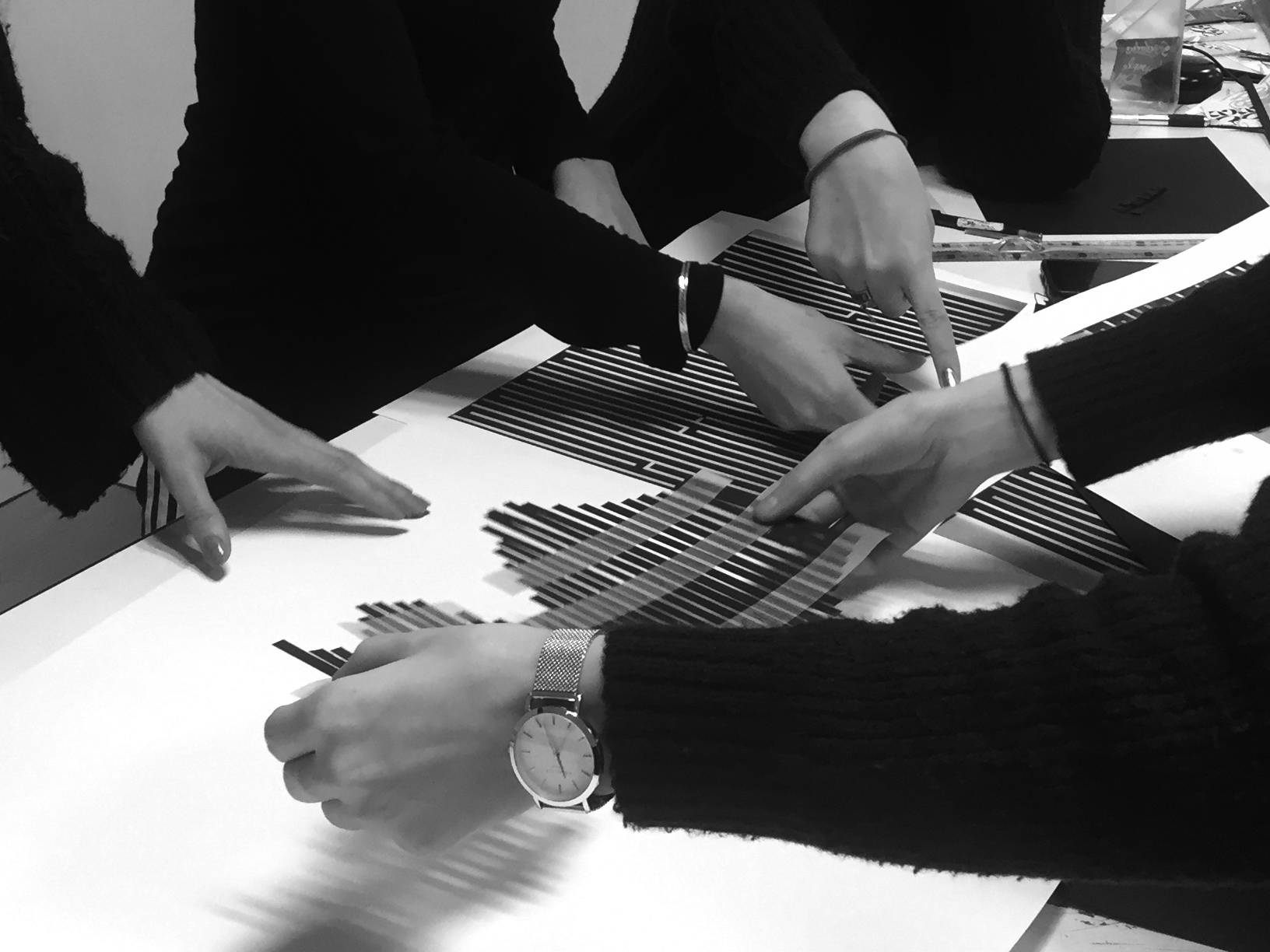 Photographie montrant 4 filles en train d'agencer des bandes de papier noir.