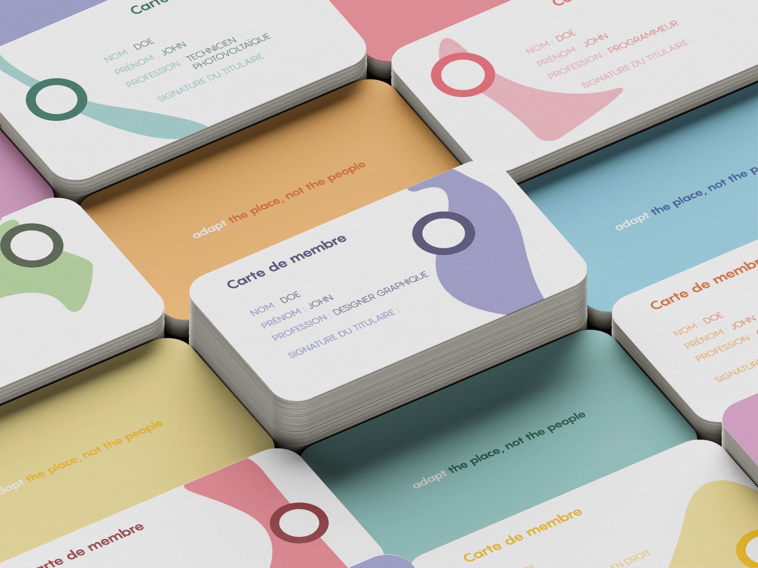 Photographie de plusieurs carte de membres adhérant au projet O. Elle sont colorées et reprennent les formes des déclinaisons du logo.